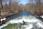 Ein Surfer surft auf der Eisbachwelle im Englischen Garten in München 